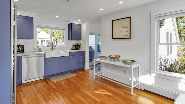 kitchen with sink, blue cabinetry, dishwasher, tasteful backsplash, and light wood-type flooring