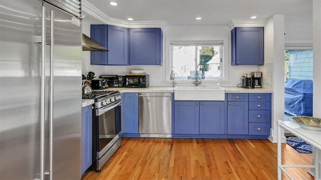 kitchen with sink, crown molding, tasteful backsplash, light hardwood / wood-style flooring, and stainless steel appliances