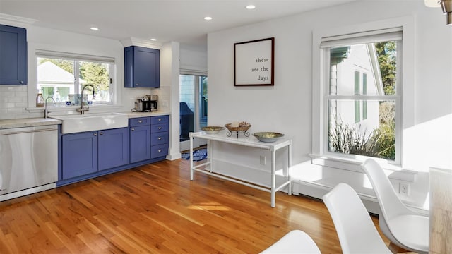 kitchen featuring dishwasher, sink, backsplash, blue cabinetry, and light wood-type flooring