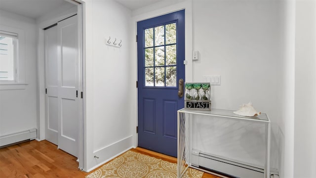 doorway to outside featuring a baseboard heating unit and light hardwood / wood-style floors