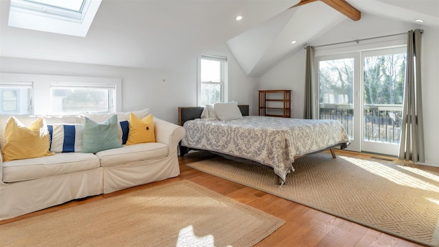 bedroom with access to exterior, light hardwood / wood-style flooring, and vaulted ceiling with skylight