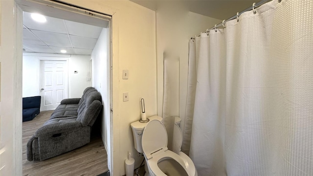 bathroom with wood-type flooring, toilet, and a paneled ceiling