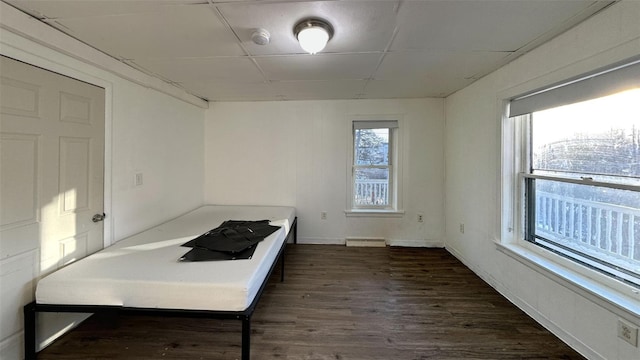 unfurnished bedroom with dark hardwood / wood-style flooring and a paneled ceiling