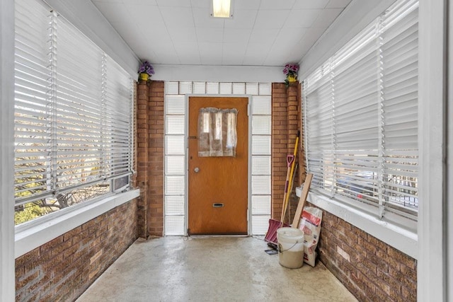 entryway featuring concrete floors and brick wall