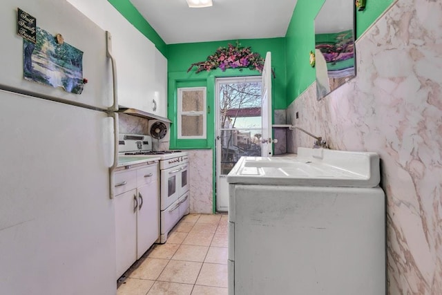 kitchen featuring white cabinetry, tile walls, white appliances, and light tile patterned flooring