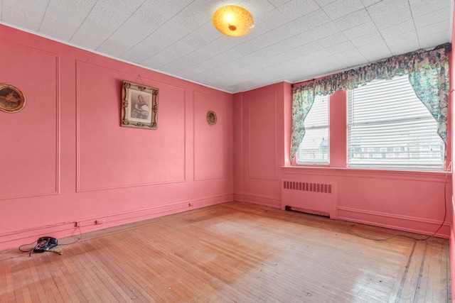 unfurnished room featuring light hardwood / wood-style flooring and radiator heating unit