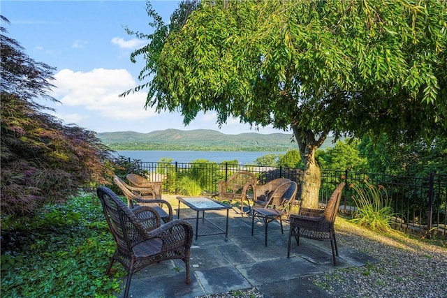 view of patio / terrace featuring a water and mountain view and an outdoor hangout area