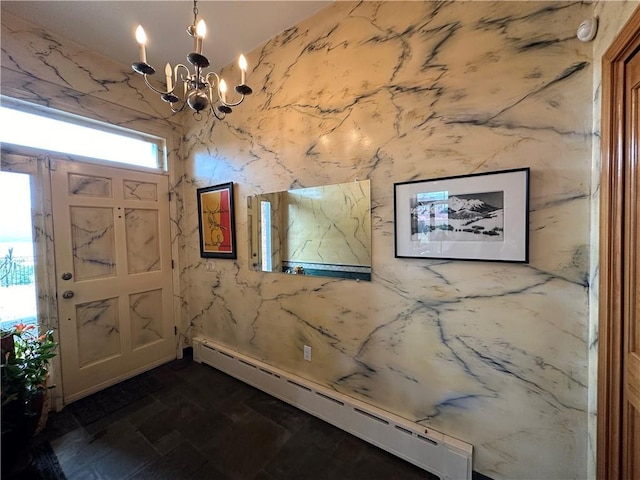 foyer with an inviting chandelier and a baseboard heating unit