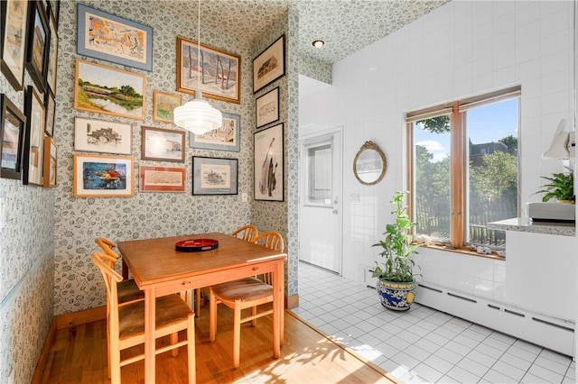 dining area featuring light tile patterned floors and a baseboard radiator