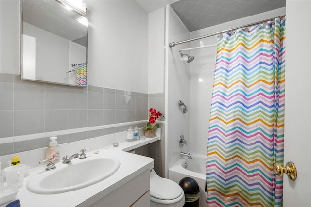 full bathroom featuring vanity, tile walls, shower / tub combo with curtain, and toilet