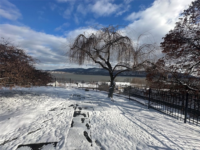 snowy yard featuring a mountain view and a rural view