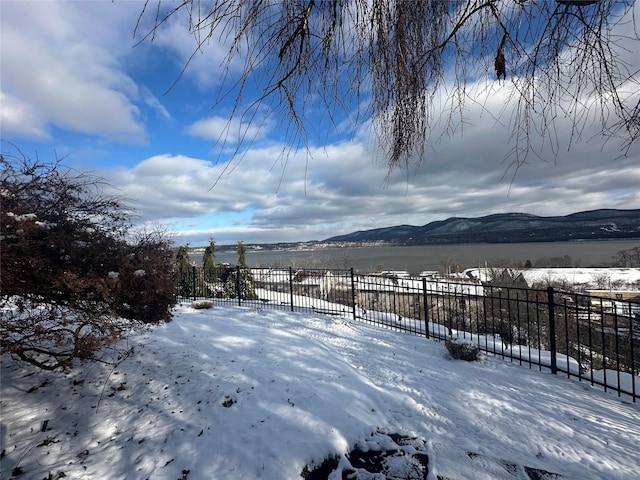 yard layered in snow featuring a mountain view