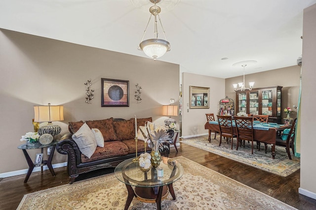 living room with dark hardwood / wood-style flooring and an inviting chandelier