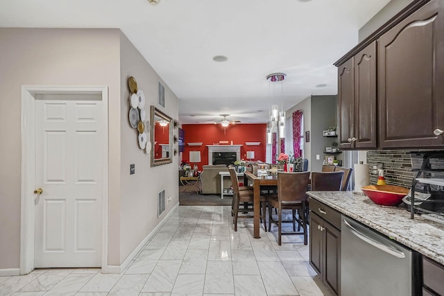 kitchen featuring ceiling fan, dishwasher, backsplash, dark brown cabinets, and decorative light fixtures