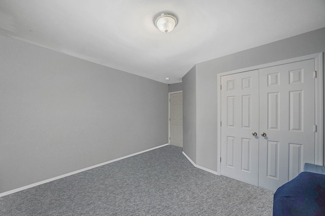 unfurnished bedroom featuring a closet and dark colored carpet