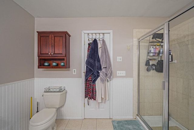 bathroom featuring tile patterned flooring, an enclosed shower, and toilet