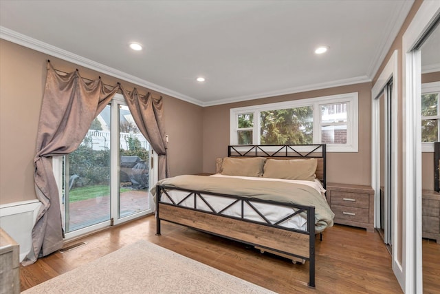 bedroom featuring multiple windows, crown molding, access to outside, and light wood-type flooring