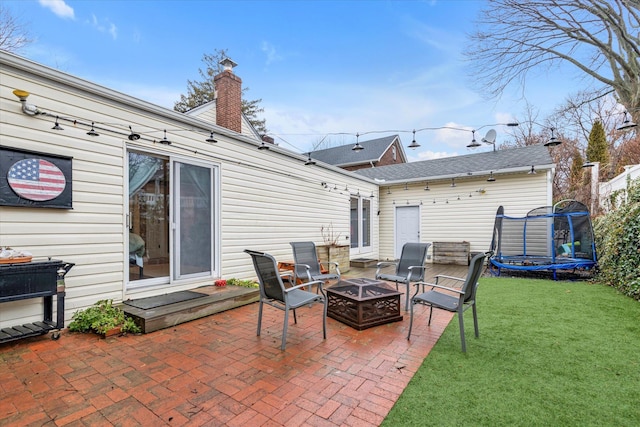 view of patio featuring a trampoline and an outdoor fire pit