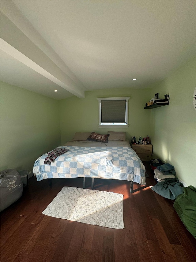 bedroom with dark wood-type flooring and beam ceiling