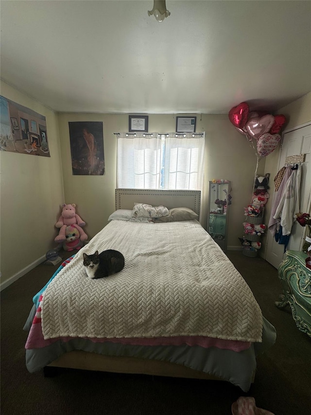 bedroom featuring dark colored carpet and baseboards