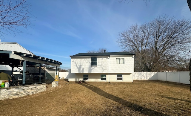 rear view of property with a lawn and a fenced backyard