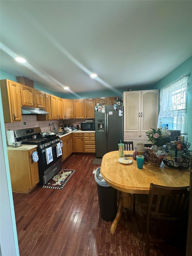 kitchen featuring stainless steel gas range, fridge with ice dispenser, light countertops, under cabinet range hood, and black microwave