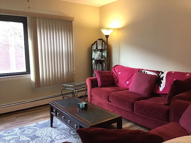 living room with wood-type flooring and a baseboard heating unit