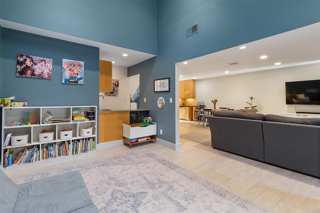 living room featuring sink and a towering ceiling