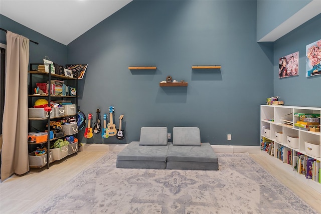 playroom featuring lofted ceiling and light hardwood / wood-style floors