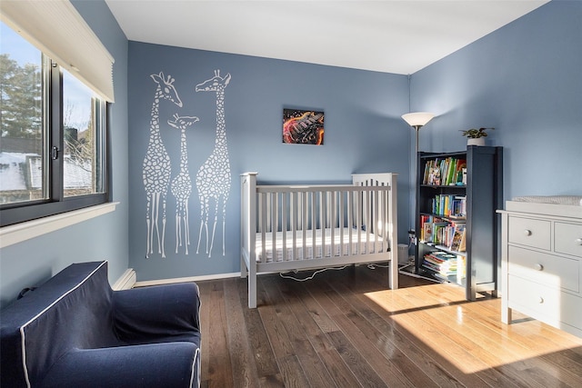 bedroom featuring a crib and wood-type flooring