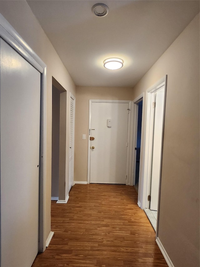 hall with wood finished floors and baseboards