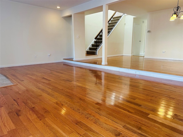 basement featuring hardwood / wood-style flooring and a notable chandelier