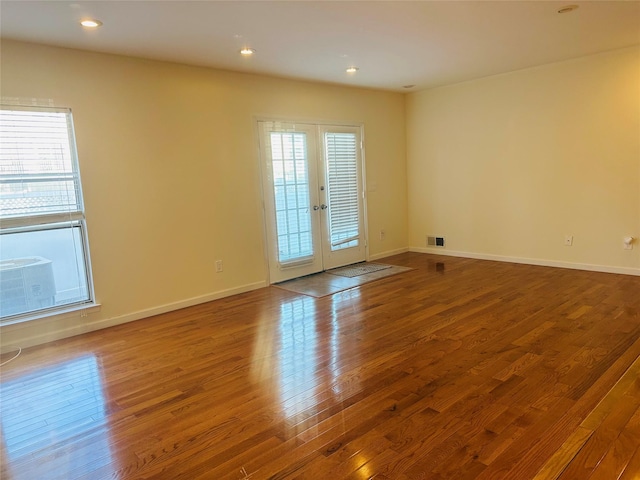 empty room with hardwood / wood-style flooring and french doors