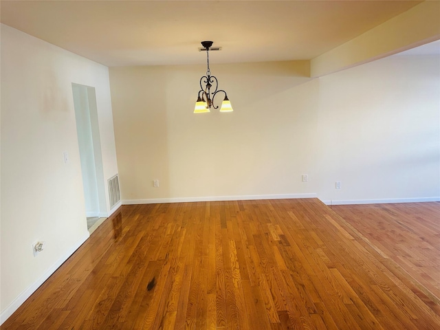 unfurnished dining area featuring hardwood / wood-style floors and an inviting chandelier