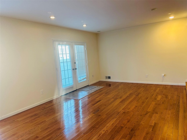 spare room with hardwood / wood-style flooring and french doors