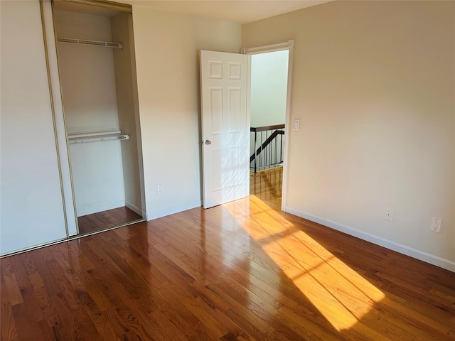 unfurnished bedroom with wood-type flooring and a closet