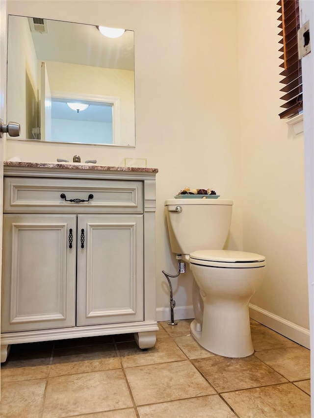 bathroom with vanity, tile patterned flooring, and toilet