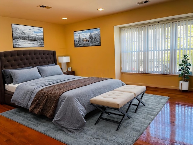 bedroom with hardwood / wood-style floors and multiple windows