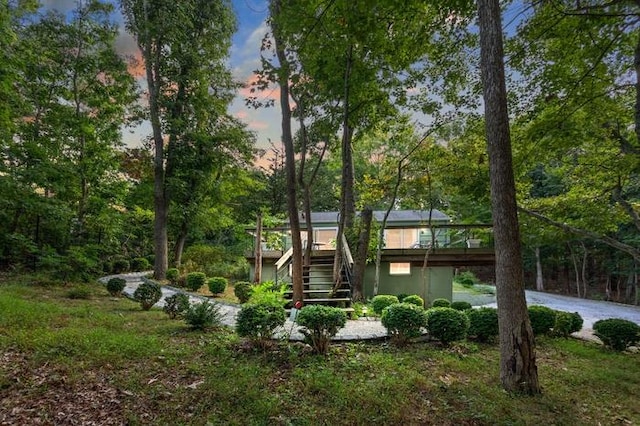 property exterior at dusk featuring a wooden deck