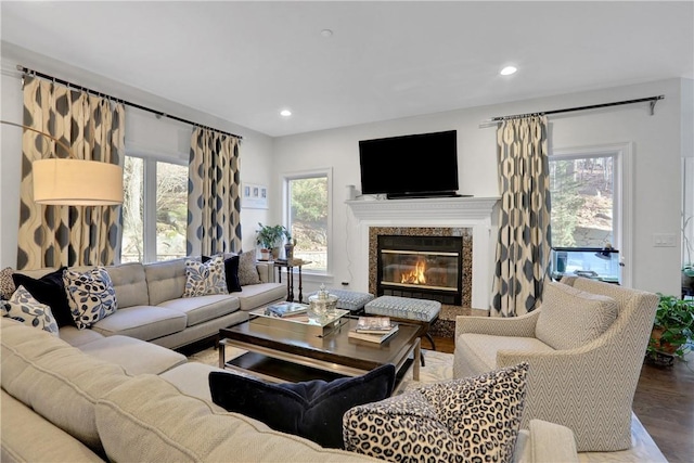 living room with a high end fireplace and wood-type flooring