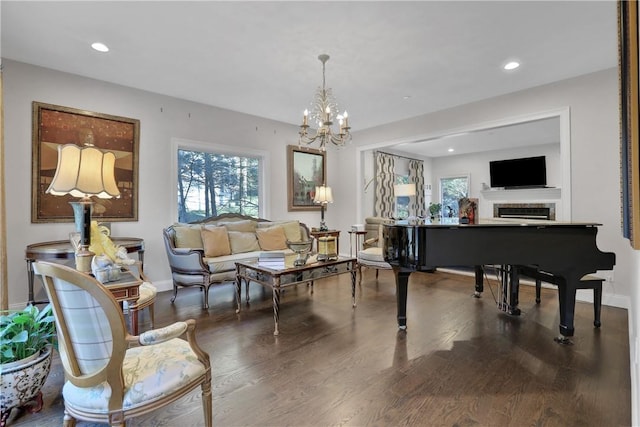 living area featuring dark hardwood / wood-style floors, a wealth of natural light, and a notable chandelier