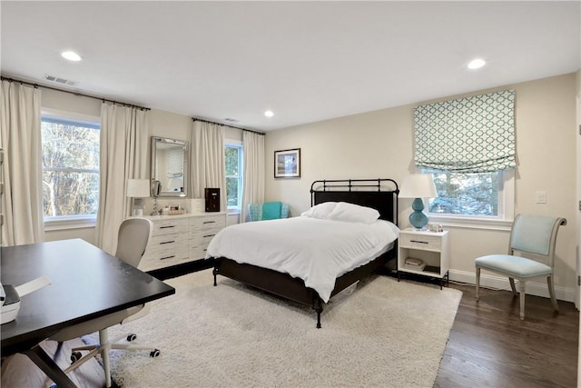 bedroom featuring dark hardwood / wood-style floors and multiple windows