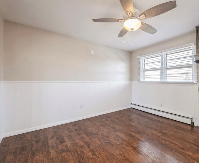 spare room with ceiling fan, dark hardwood / wood-style flooring, and a baseboard heating unit