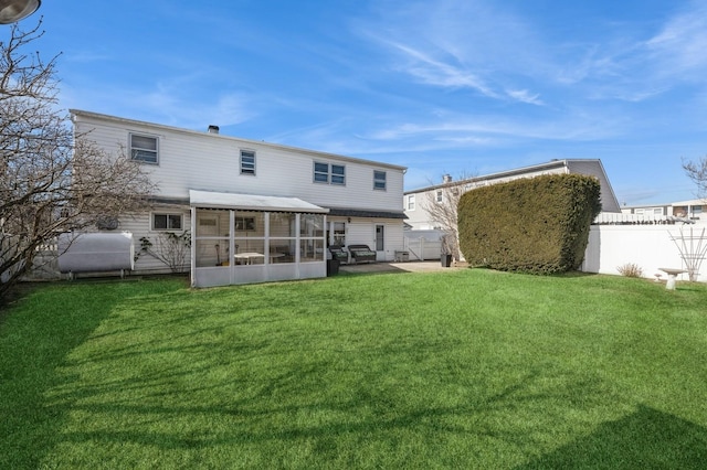 rear view of property featuring a sunroom and a lawn