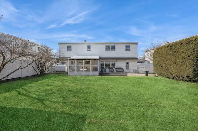 back of house featuring a yard, a patio area, and a sunroom