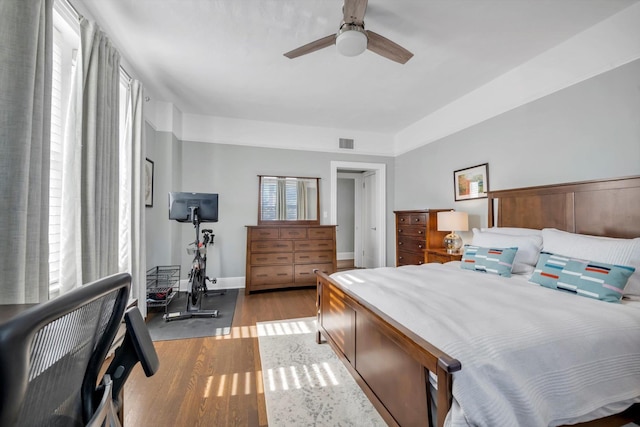 bedroom with light wood-type flooring, ceiling fan, and multiple windows