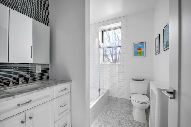 bathroom with toilet, tile patterned floors, vanity, and tasteful backsplash