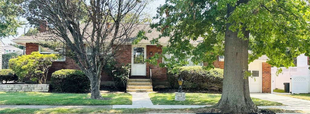 obstructed view of property with a front lawn