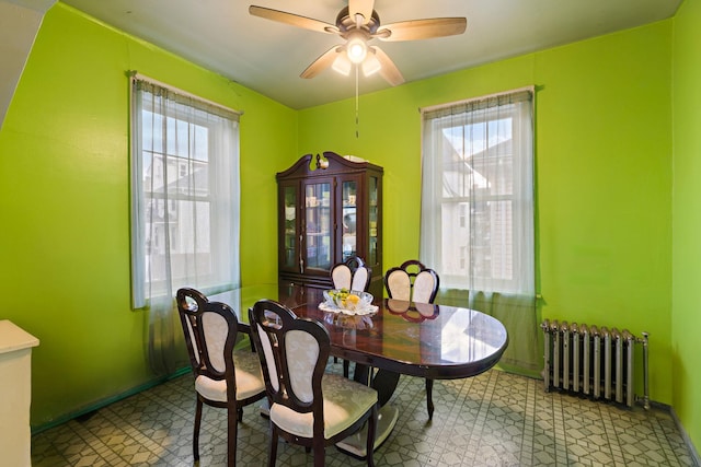 dining area featuring ceiling fan, radiator heating unit, and a wealth of natural light