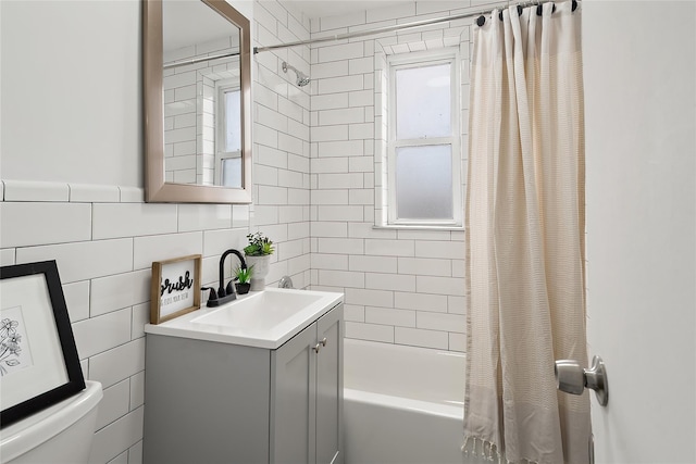 bathroom featuring tile walls, vanity, and shower / bath combo